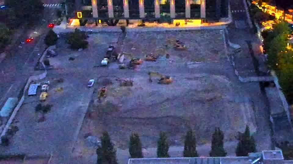 The site is now illuminated, revealing several pieces of heavy equipment positioned across the graded area. Visibility has improved, and the layout of machines appears largely unchanged from the earlier frame.
