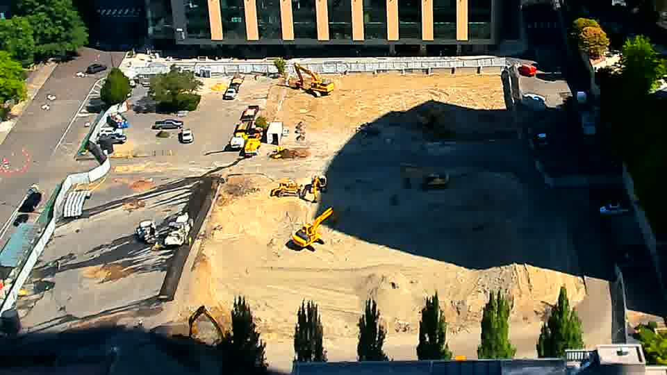 The site appears largely unchanged, with the equipment and stockpiled material holding their positions from the previous view.