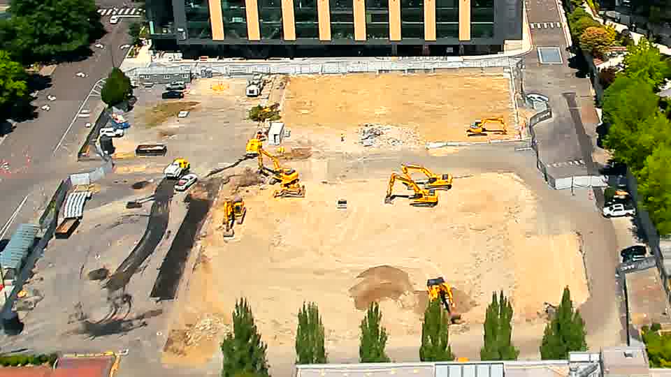 One of the excavators near the center of the frame has shifted position, and a small amount of material appears to have been redistributed around it.
