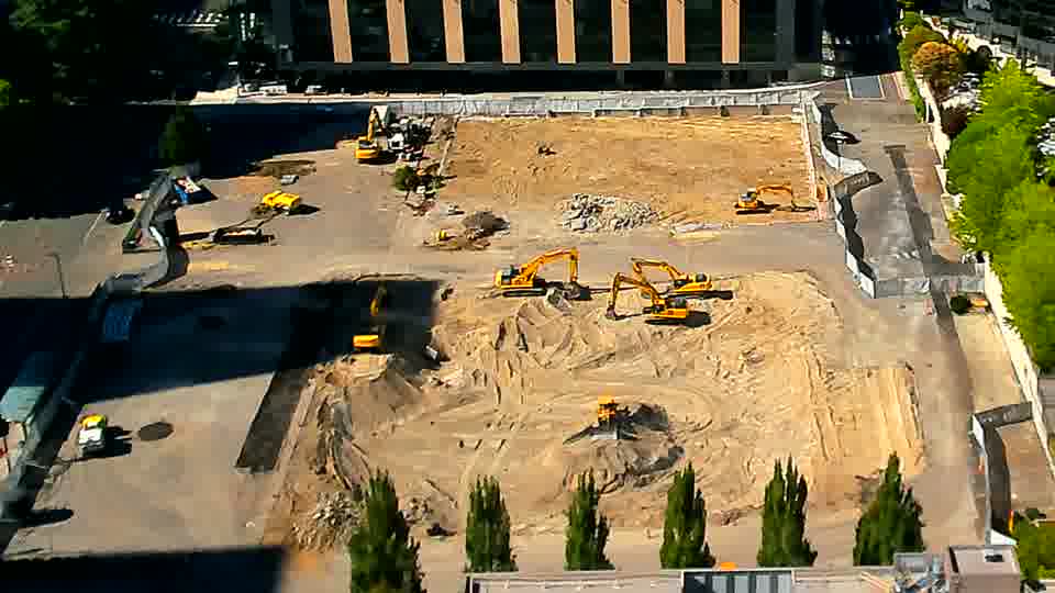 A yellow machine has shifted position in the foreground, moving slightly to the right since the last view.