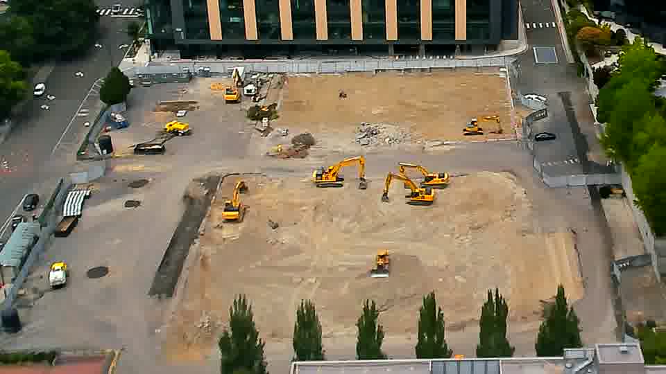 The arrangement of the heavy equipment appears largely unchanged, though one excavator near the center of the site seems to have shifted its boom position.