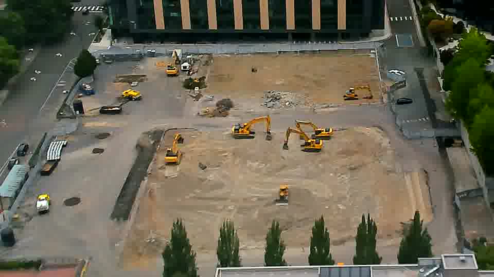 The layout of equipment across the site remains largely unchanged, though a small yellow machine has shifted position slightly near the center.