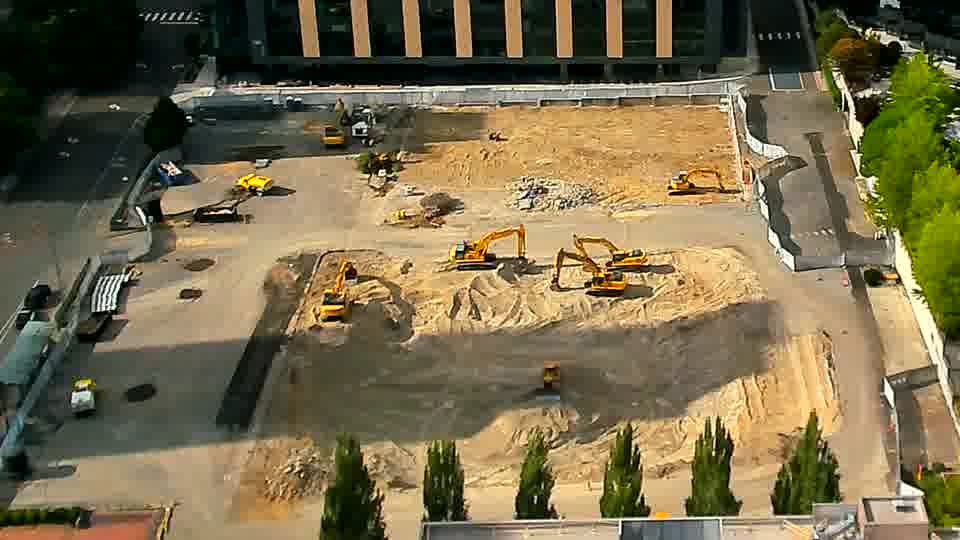 The scene remains largely unchanged, though one of the excavators near the center of the frame appears to have rotated slightly.