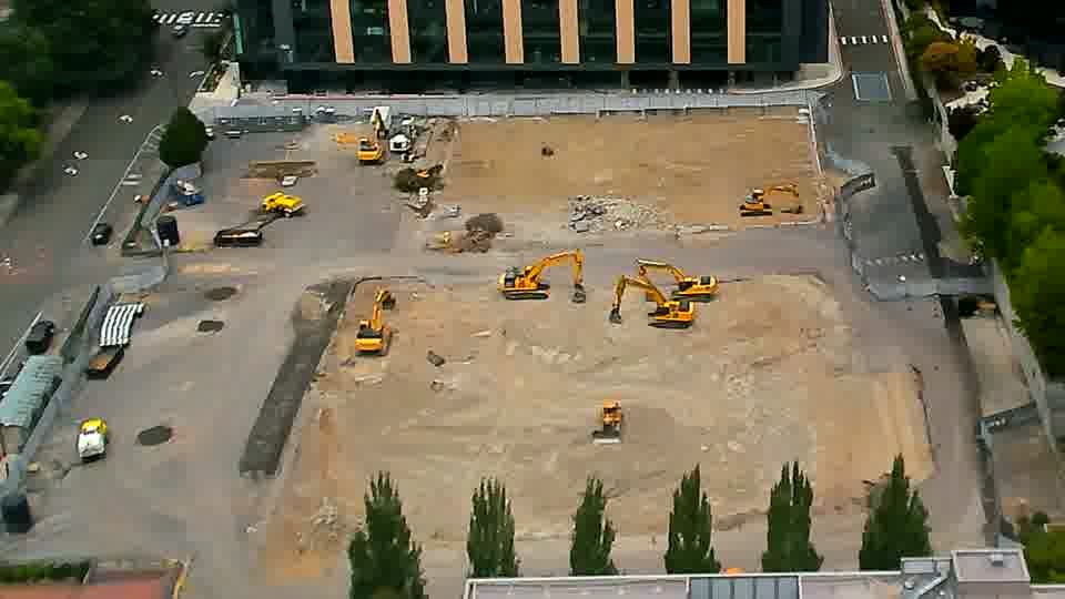 The scene remains largely static, with the machinery holding its positions across the work area.