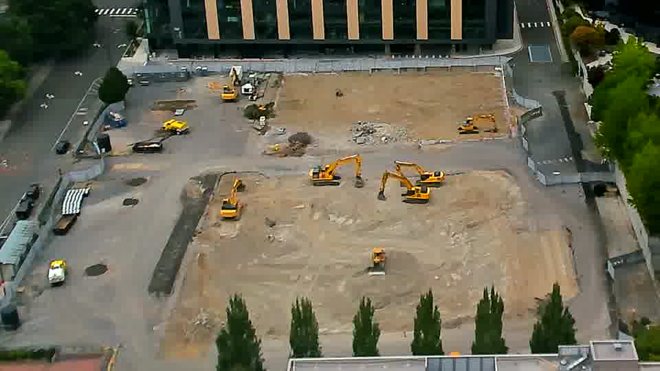 A white vehicle has entered the site via the driveway on the left side of the frame.