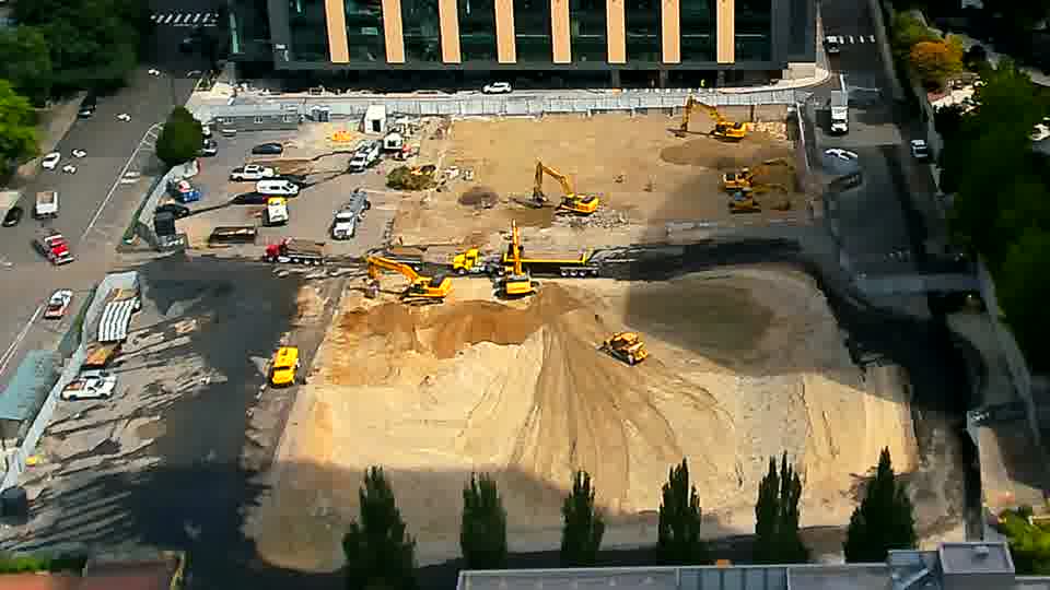 The arrangement of machinery remains mostly unchanged, though one of the excavators closer to the foreground has shifted its position slightly.