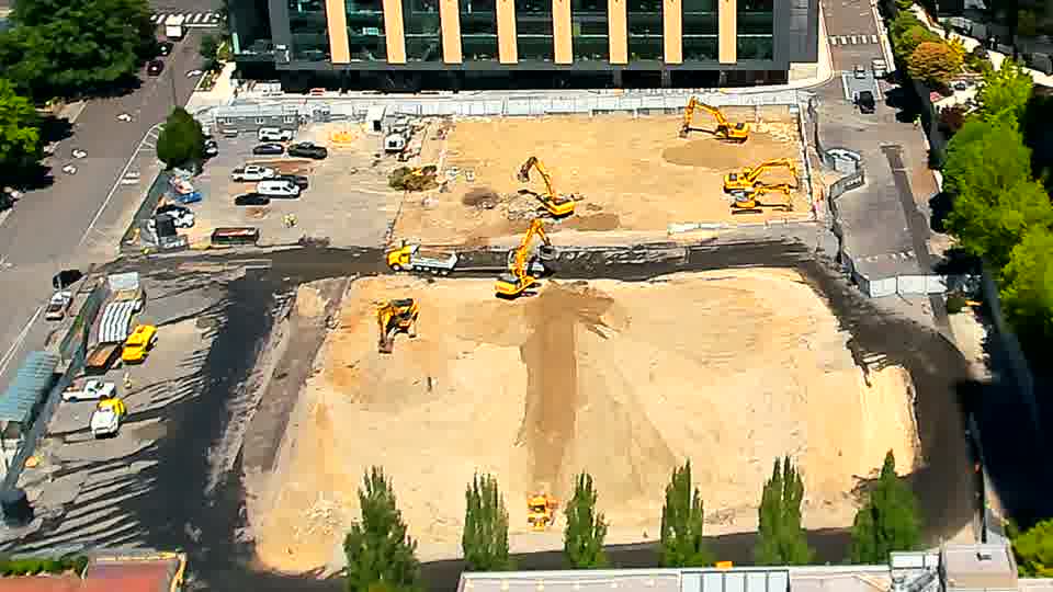 A small cluster of vehicles has appeared near the service road on the right side of the frame.