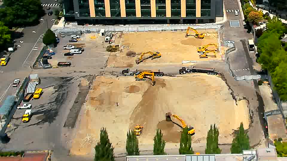 One of the excavators near the center of the site has shifted position, now angled slightly differently toward the lower edge.