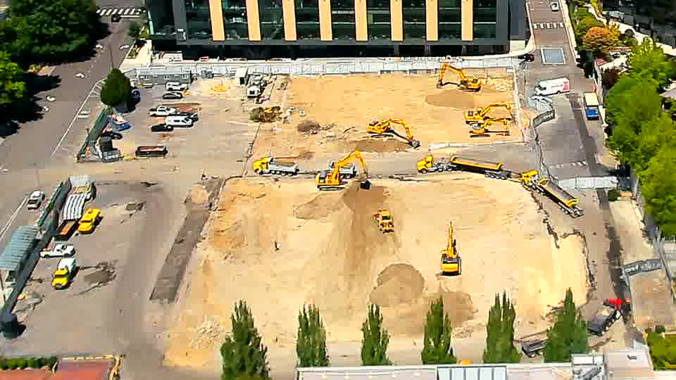 The arrangement of machinery appears mostly unchanged, though one excavator closer to the foreground now faces a slightly different direction.