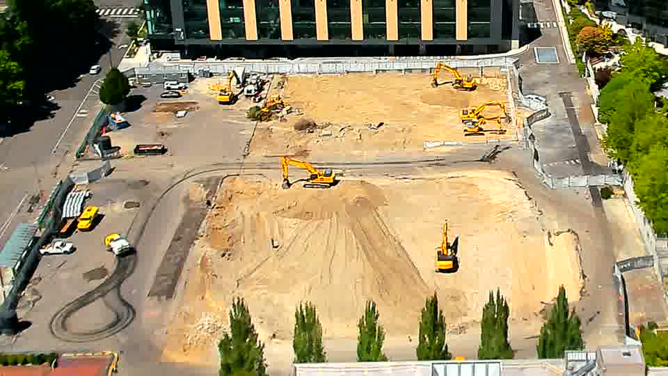 A white van has entered the site from the driveway on the left and is now parked near the equipment cluster in that area.