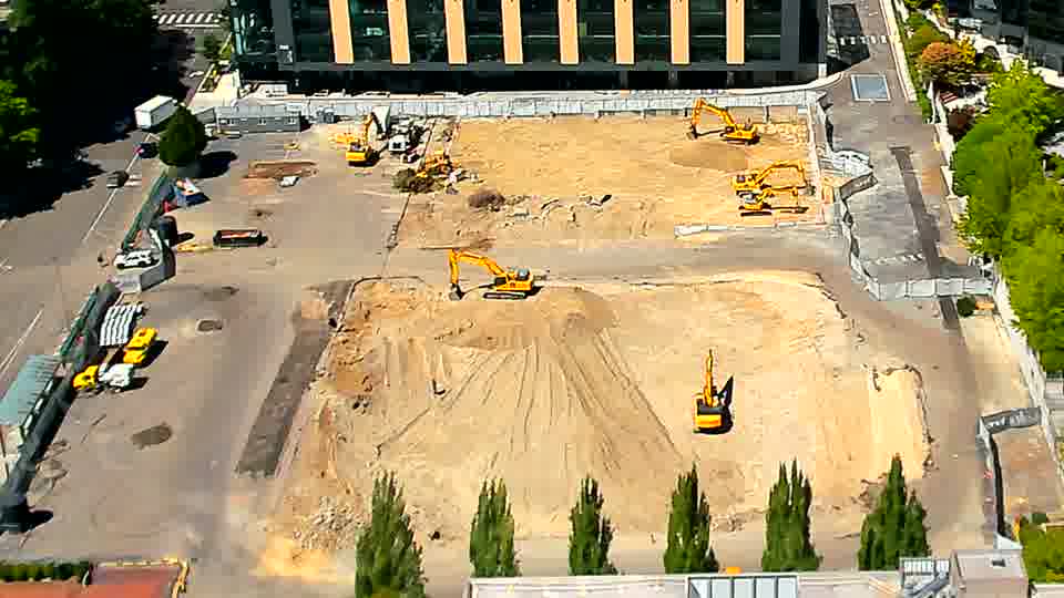 The site remains largely static, with the positions of the heavy equipment appearing consistent between the two views.