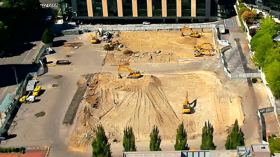 The site appears quiet, with no discernible changes in the positions of the machinery or vehicles.