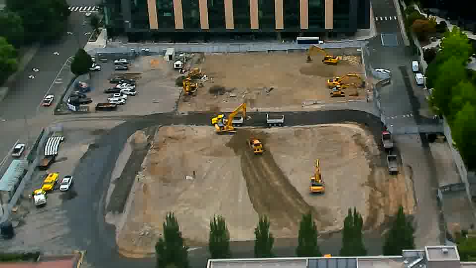 An excavator near the bottom of the frame is now oriented in a different direction, having rotated its cab toward the upper right.