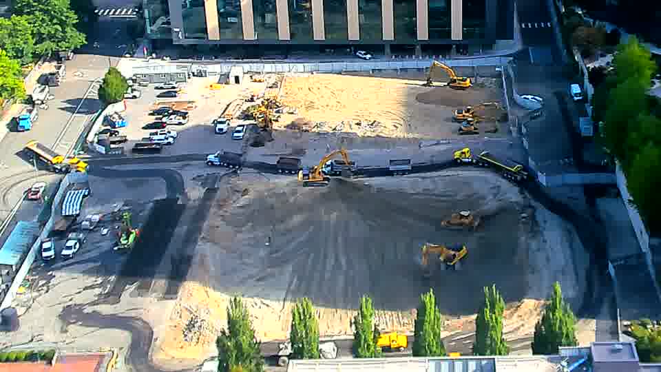 An excavator near the center of the frame has rotated slightly, facing a different direction than before.
