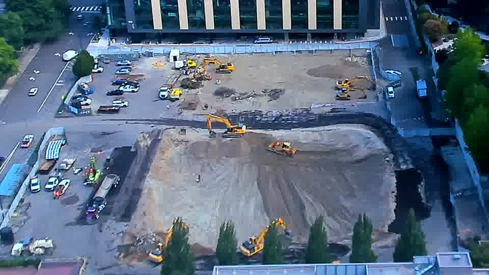 One of the excavators near the center has moved a short distance, now angled toward the lower edge of the frame.