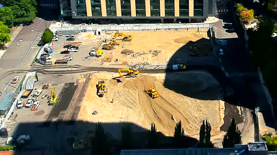 The equipment arrangement holds steady, though sunlight has noticeably altered the shadows across the site.