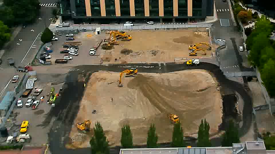 The arrangement of machinery across the site remains consistent, though a slight shift in shadows suggests the sun has moved.