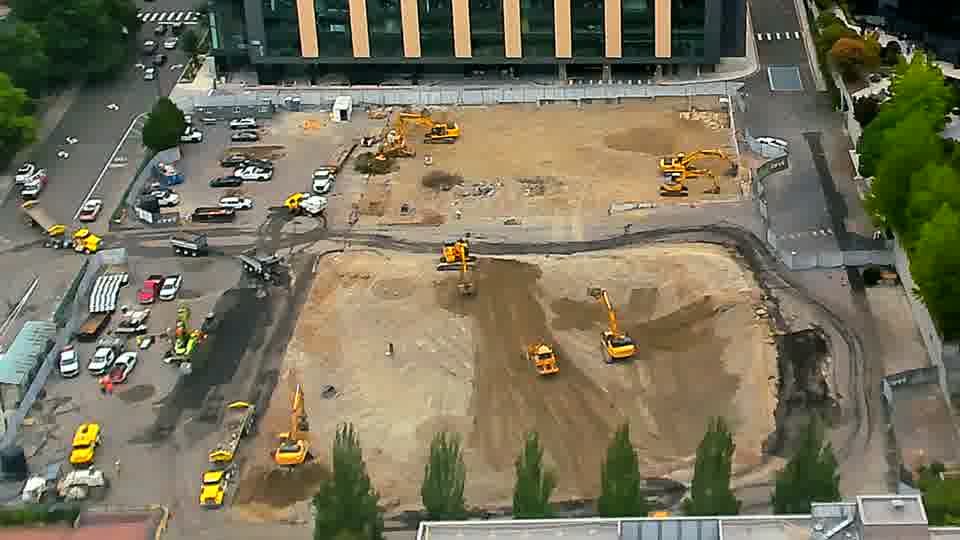 The heavy equipment across the site maintains its arrangement, with no discernible movement of the machines or vehicles in either direction.