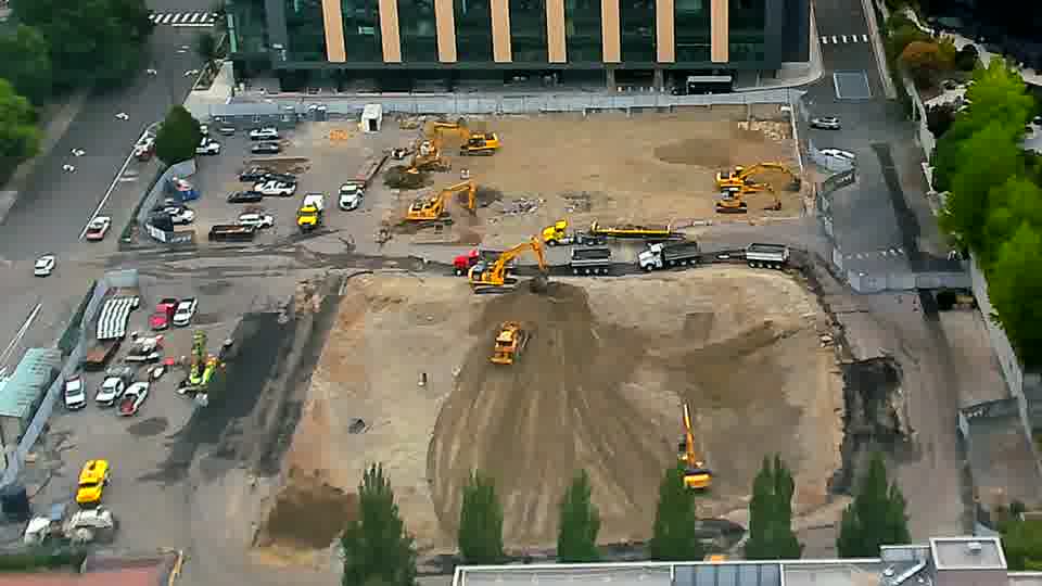 One of the excavators near the center of the site has shifted its position slightly, now facing a different direction. Otherwise, the scene appears unchanged, with the equipment spread across the work area as before.