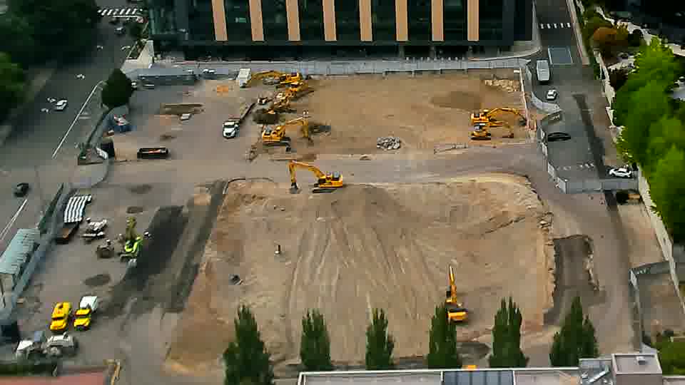The view across the site remains consistent, with no apparent shifts in the positions of the machines or materials.