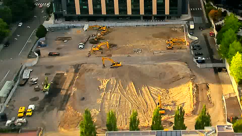 The layout of equipment on site is holding steady, with no noticeable repositioning of the machines or materials.