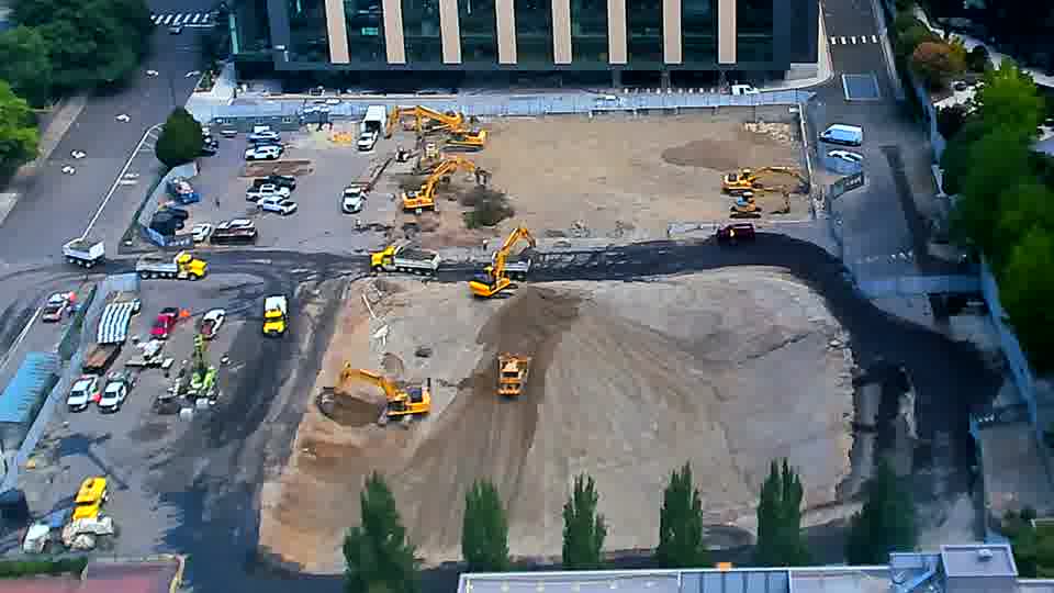 The arrangement of machines across the site appears remarkably static, though a few more vehicles are now lined up near the left-side driveway.