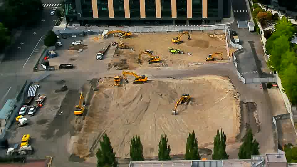 A white van has entered the site via the driveway on the left, parking among other vehicles.