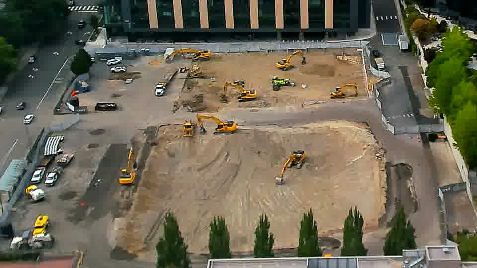 The scene is remarkably consistent, with the heavy equipment remaining in essentially the same positions.