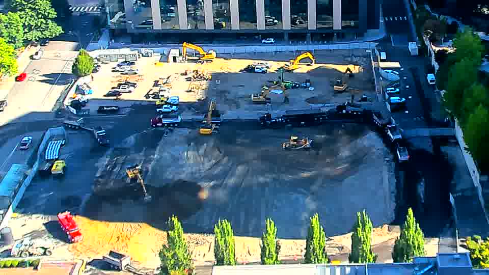 The arrangement of machinery across the site appears largely unchanged, though shadows have shifted with the sun's movement.