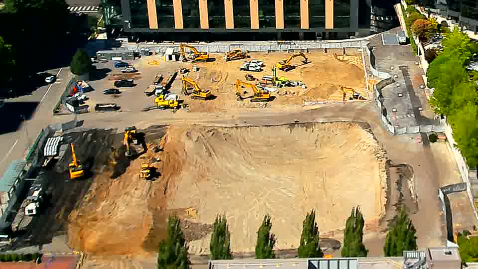 A lone white pickup truck has entered the site through the driveway on the left side of the frame.