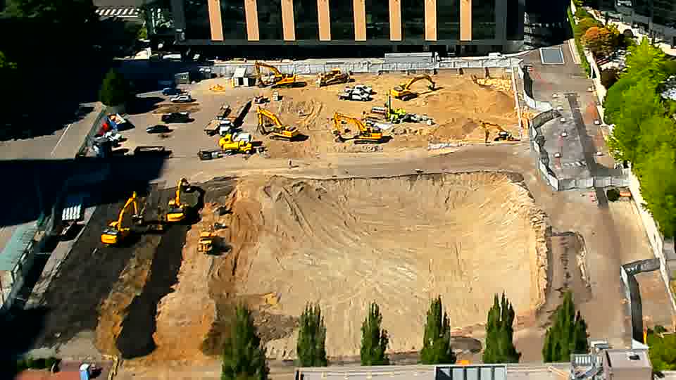 Two excavators have moved into the left-hand trench area near the bottom of the frame, shifting positions since the last view.