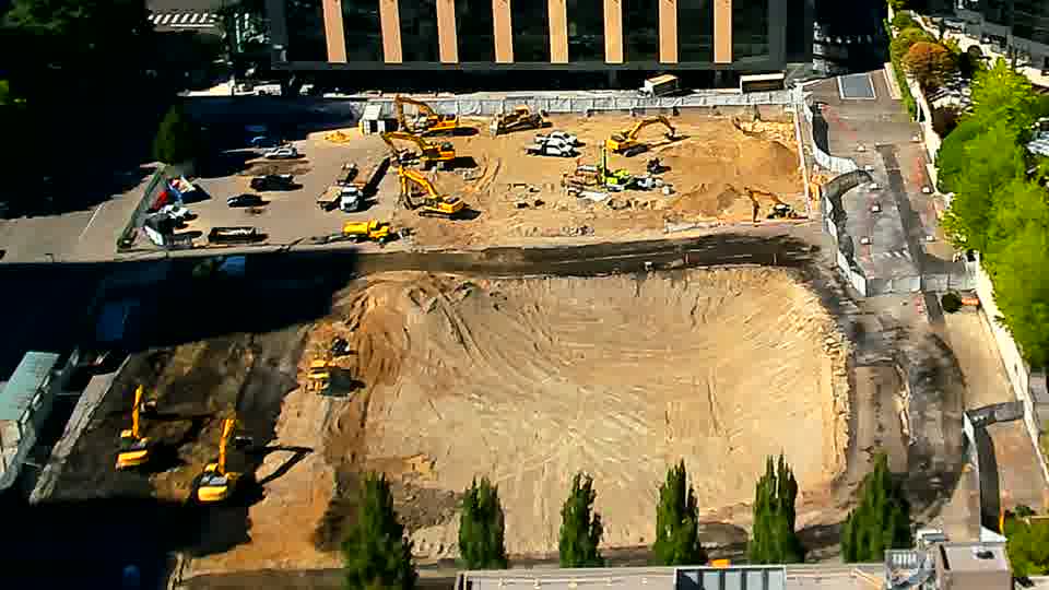 The scene appears largely static, with the heavy equipment maintaining its previous positions across the site.