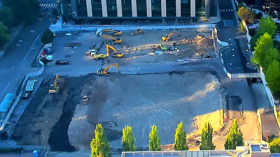 The equipment arrangement appears nearly unchanged, though a white trailer now sits near the center of the site.