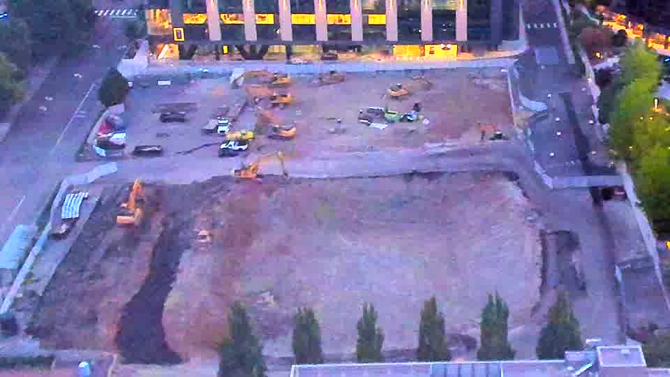 The site is now illuminated, revealing several pieces of heavy equipment positioned across the graded area. Visibility has improved significantly since the last check, and the scene appears largely unchanged in terms of machine placement.