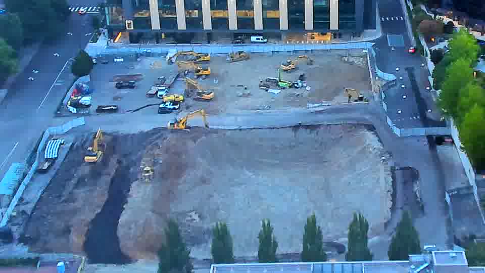 The compact drill rig in the southwest corner has shifted slightly eastward. Otherwise, the arrangement of equipment across the site remains consistent between these views.
