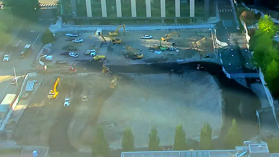 The yellow machine near the lower-right has altered its position slightly, now facing more directly toward the camera. The rest of the site’s layout and equipment locations appear unchanged.