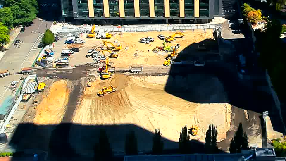 The arrangement of equipment and materials across the site appears remarkably consistent, with only minor shifts in shadow patterns.