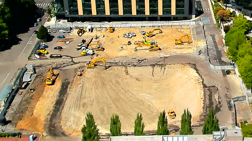 The arrangement of equipment across the site is nearly identical to the previous view, though a small pile of material has appeared near the center.
