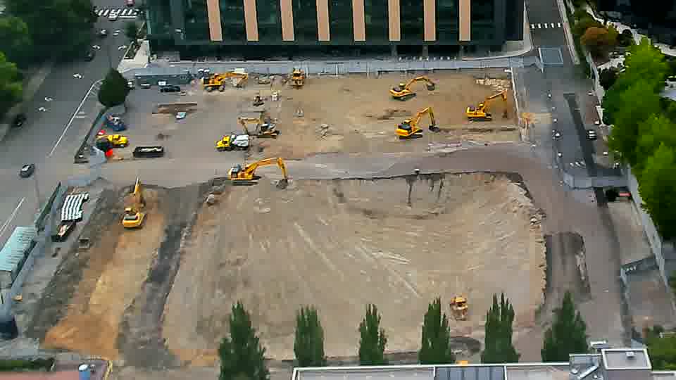 The layout of equipment remains consistent, though one of the excavators near the center of the frame has subtly shifted its position.