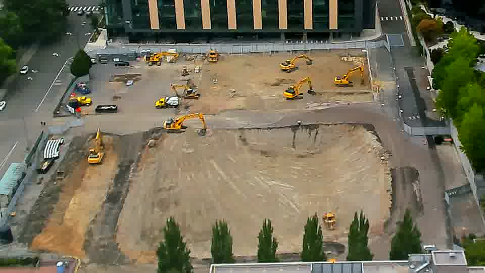 A small yellow machine has appeared near the lower-right corner of the site, while the rest of the equipment remains in place.