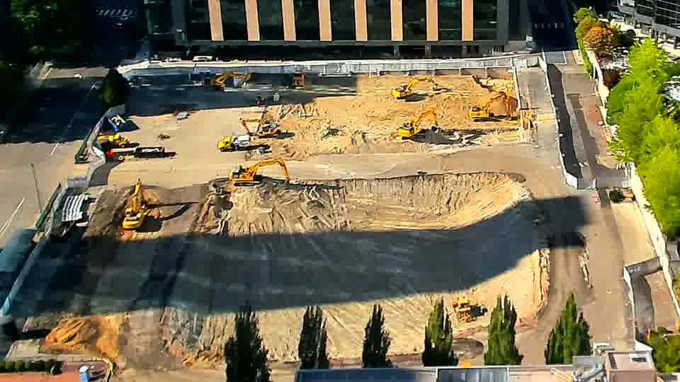 The arrangement of machines across the site remains constant between these views.