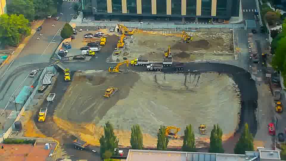 The site appears largely as it was fifteen minutes ago, with no obvious repositioning of equipment or vehicles.