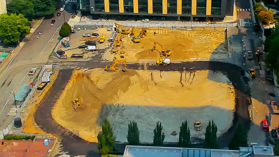The site remains remarkably unchanged, showing no significant movement of equipment or materials in the last quarter hour.