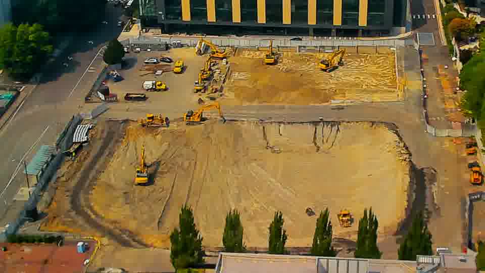 The scene is largely static, though a small piece of machinery has appeared near the lower-right corner of the site.