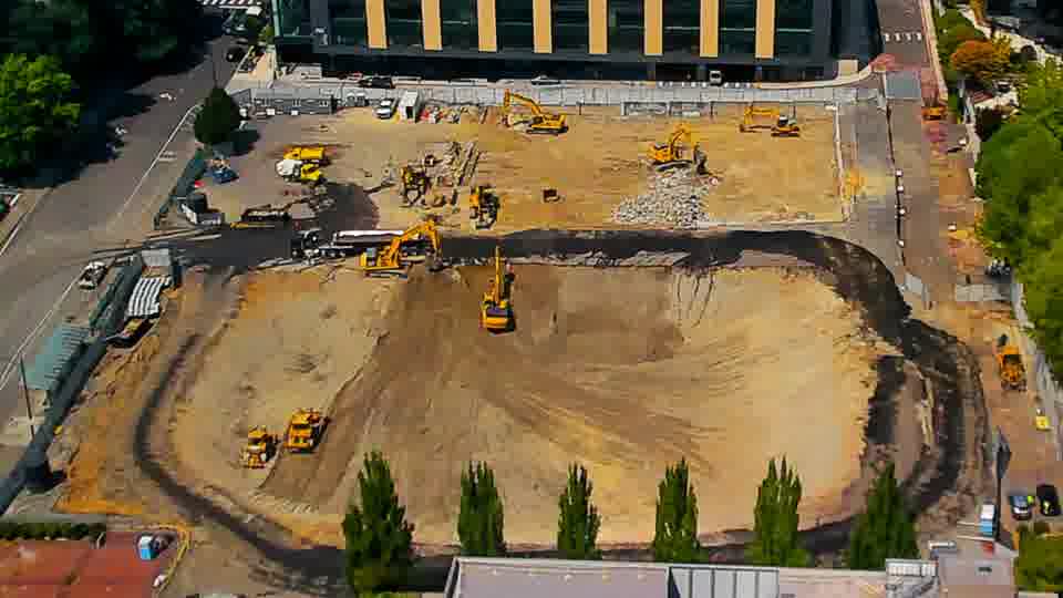 The equipment arrangement remains consistent, although the texture of the worked area in the lower center of the site has been further refined.