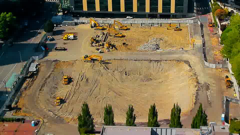The site displays a static scene, with the positions of the machinery and ground patterns remaining consistent.