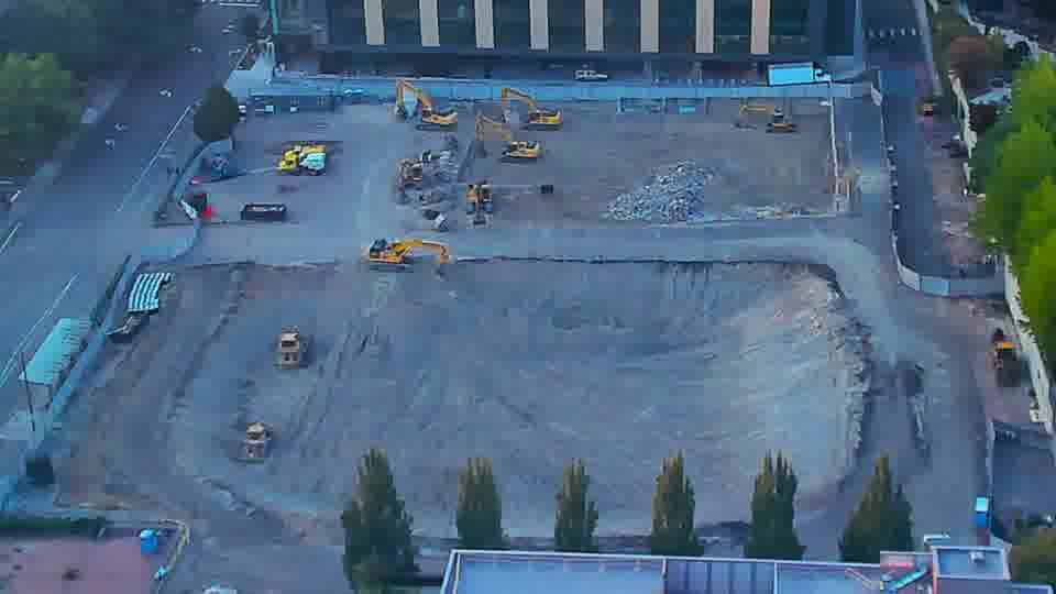 Activity on the right side of the site has increased, as a piece of machinery is now visible near the service road that wasn't there before.