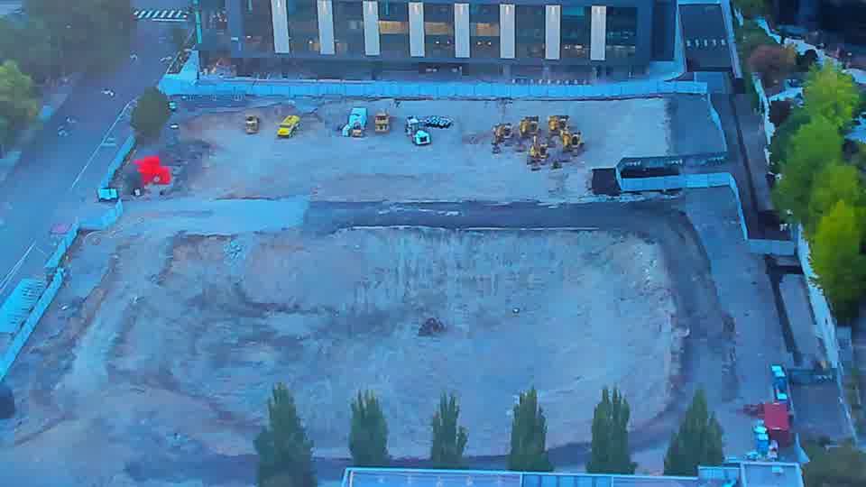Construction camera frame at 7:00 AM PT. The arrangement of equipment on the site remains consistent between these views, showing no movement or new arrivals.