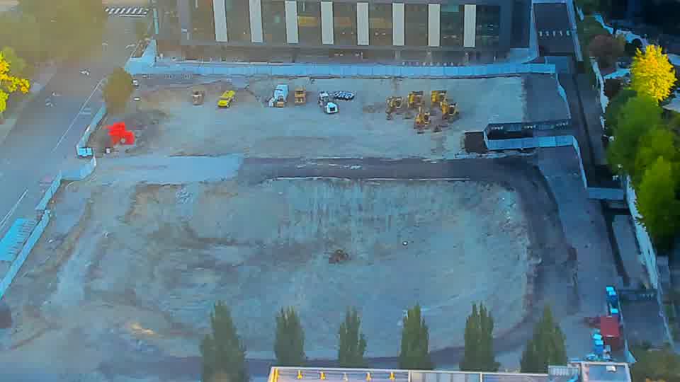 Construction camera frame at 7:15 AM PT. The scene presents a familiar view, with all equipment remaining in the same positions as fifteen minutes ago.