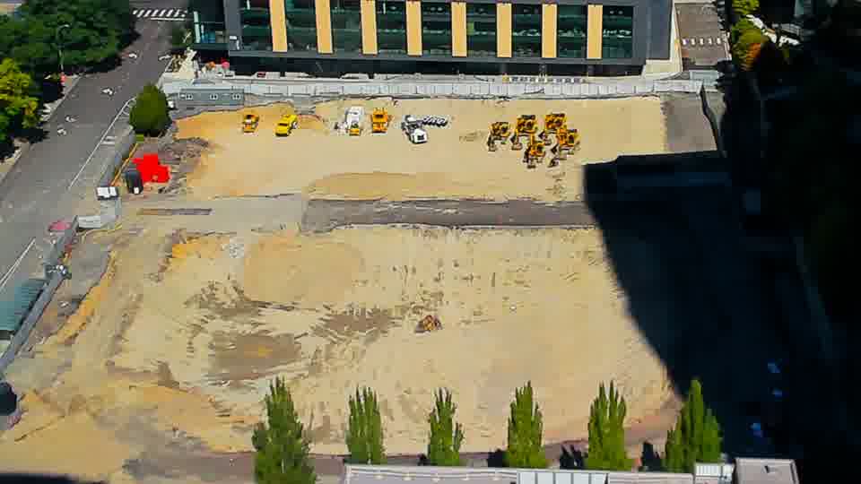 Construction camera frame at 12:30 PM PT. The site maintains its current appearance, with no visible alterations to the equipment or materials within the frame.